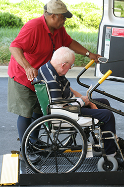 Chauffeur aidant quelqu'un en fauteuil roulant